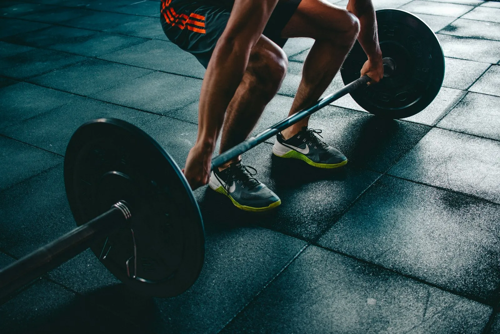 A loaded barbell on a gym floor, ready for a lift