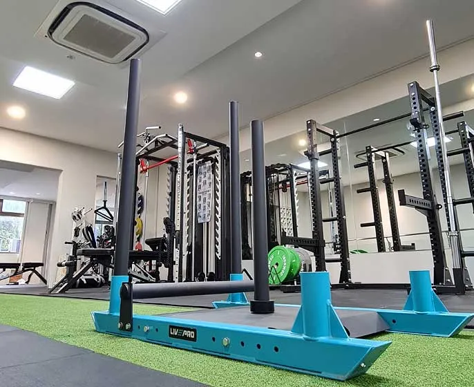 Squat racks, sled and turf training area at the Flex Fitness studio